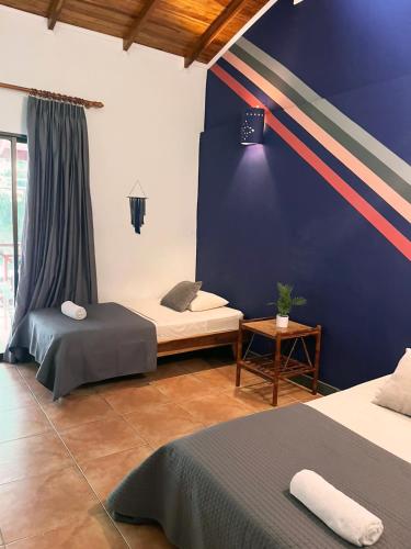 a room with two beds and a blue wall at Point Break Santa Teresa in Santa Teresa Beach