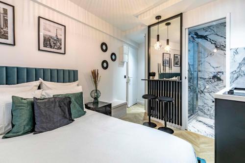 une chambre avec un lit blanc et une salle de bain dans l'établissement le studio velasquez, à Paris