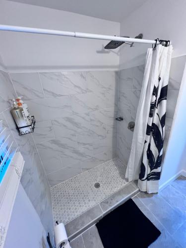 a bathroom with a shower with a black and white shower curtain at Comfortable 3BR Close to All in Dayton
