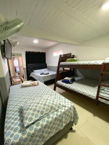 a bedroom with two bunk beds and a couch at Hotel Ciudad Señora Buga in Buga