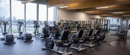 a gym with rows of treadmills and elliptical machines at Angela's Private Suites in Surrey