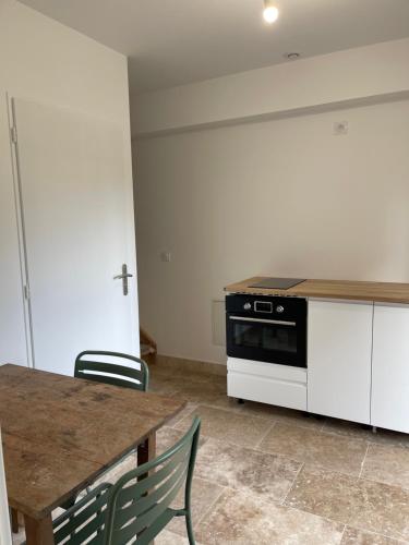 une cuisine avec une table et une cuisinière dans l'établissement La Grange de l'Aube Epine, à Haute-Épine