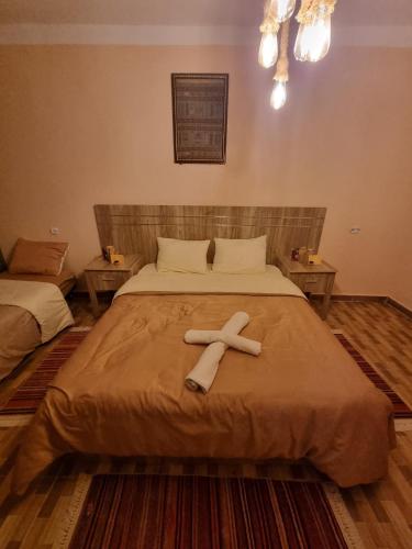 a large bed with a cross on top of it at HABIB Farm in Rhardaïa