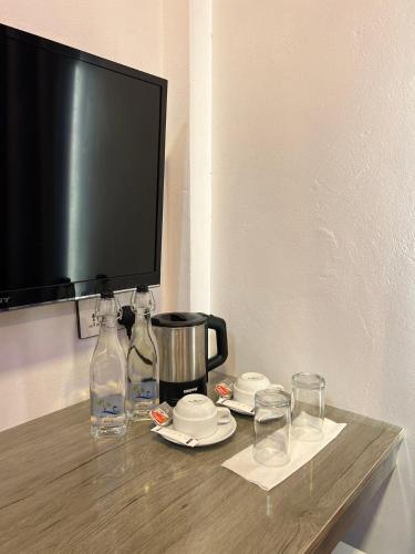 a tv sitting on top of a wooden table with glasses at INFINITE LAGOON in Mandhoo