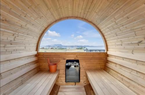 an inside view of a wooden sauna with a window at Cozy Cabin with Hot Tub & Sauna - Ultimate Retreat in Veiðilundur