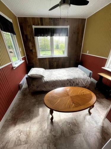 a room with two beds and a coffee table at Cozy Country Vacation Home in Scoudouc