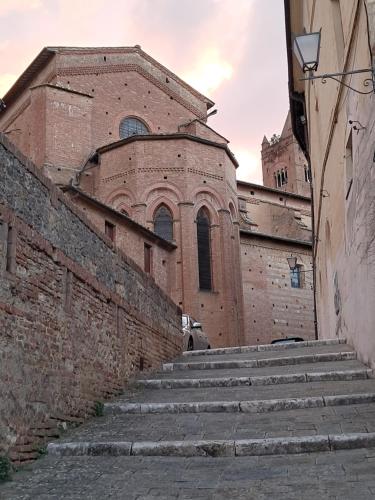 an old brick building with stairs in front of a building at Hotel Minerva in Siena