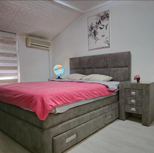 a bedroom with a large bed with a red blanket at Apartment Center 23 in Podgorica