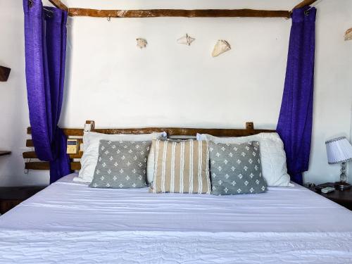 a bed with purple curtains in a bedroom at Sunset Samana in Las Galeras