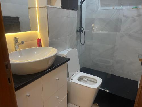 a bathroom with a sink and a toilet and a shower at Chez Lena, Appartement confortable 3 chambres in Praia