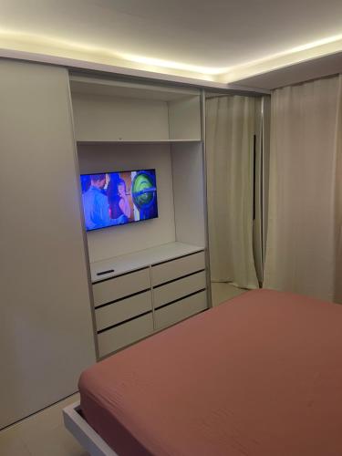 a bedroom with a bed and a television in it at Chez Lena, Appartement confortable 3 chambres in Praia