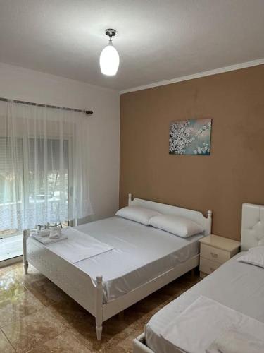 a bedroom with two beds and a window at Tranquil Lakehouse in Shkodër