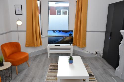 a living room with a tv and a chair at Modern Retreat Your Birkenhead Heaven, A Peaceful Getaway in Birkenhead