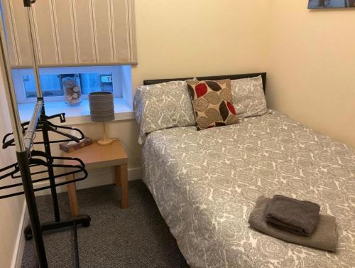 a bedroom with a bed and a table and a window at 103 NELSON STREET Hailey in Largs