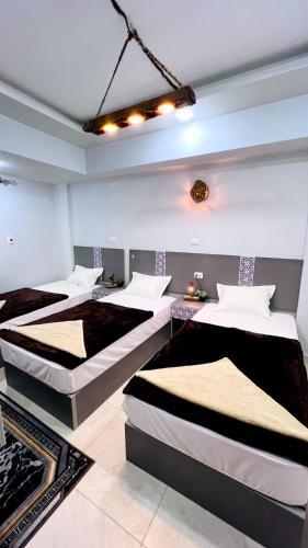 a bedroom with three beds in a room at The Home Siwa ذا هوم سيوة in Siwa