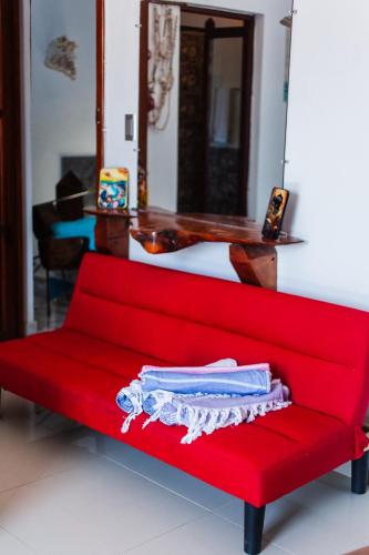 a red couch with a shirt on it in a room at Sunset Samana in Las Galeras