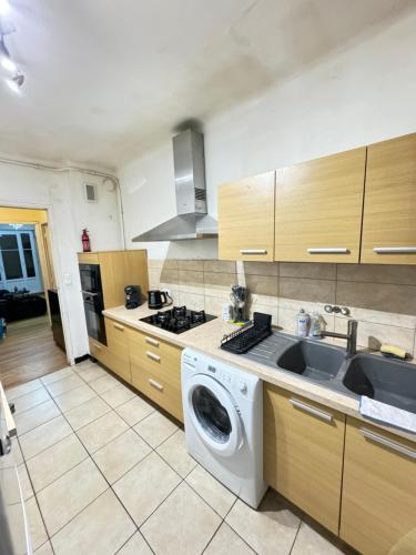 une cuisine avec une machine à laver et un évier dans l'établissement Appartement proche métro la Timone pour 4 pers Avec 2ch, à Marseille