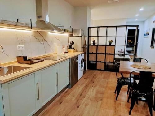 Una cocina con fregadero y una mesa con sillas. en Artes y ciencias D with fast Wifi and terrace, en Valencia