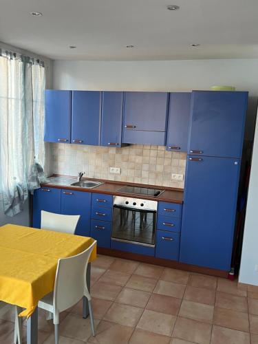 a kitchen with blue cabinets and a yellow table at Rue HENRY BENNET in Menton