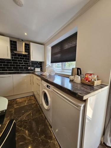 a kitchen with a washer and dryer on a counter at Spacious Guest Suite - Harrow in London