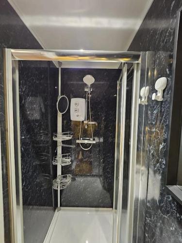 a bathroom with a shower with a glass door at Spacious Guest Suite - Harrow in London