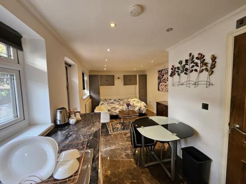 ロンドンにあるSpacious Guest Suite - Harrowのベッド、テーブル、キッチンが備わる客室です。