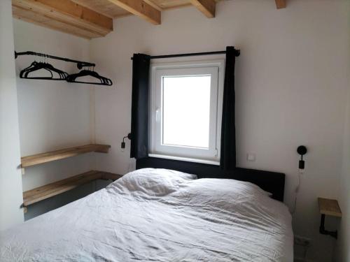 a bedroom with a large bed and a window at De Heide in Wijnjewoude