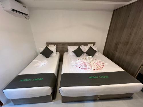 two beds in a small room with two bedsitures at INFINITE LAGOON in Mandhoo