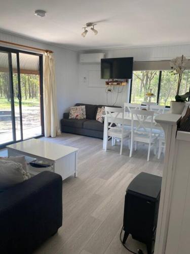 a living room with a couch and a table at Hunter Hideaway Cottages in Rothbury