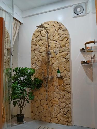 a bathroom with a shower in a stone wall at Villa Silana in Moalboal