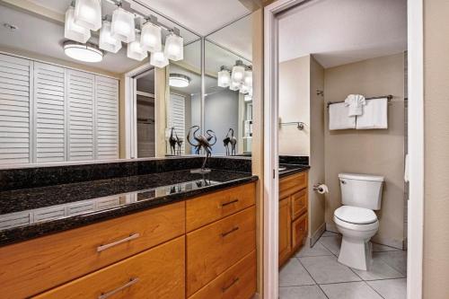 Un baño con inodoro y un espejo grande. en Mahana 803, en Kahana