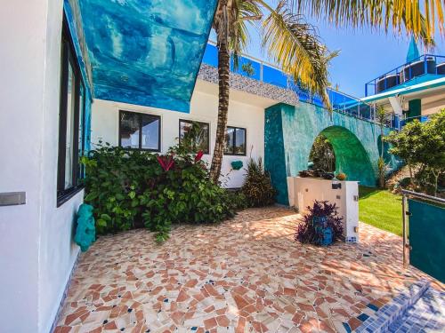 an exterior view of a house with a palm tree at Sunset Samana in Las Galeras