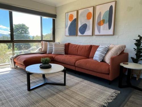 a living room with a couch and a table at Cobbers Rest in Jindabyne