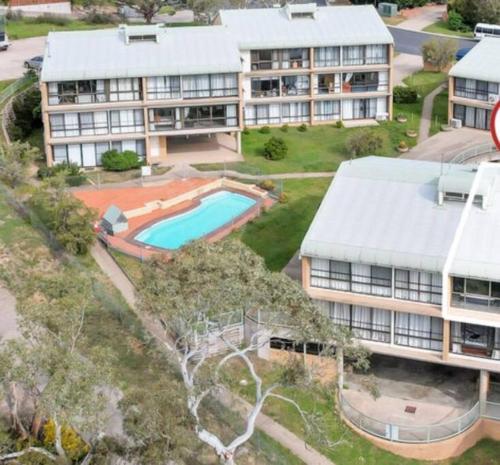 an aerial view of a building with a swimming pool at Cobbers Rest in Jindabyne