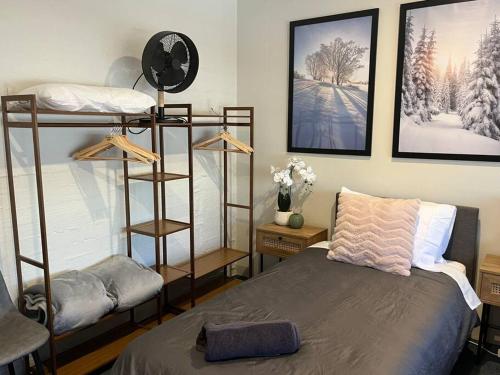 Un dormitorio con dos literas y un reloj. en Cobbers Rest, en Jindabyne