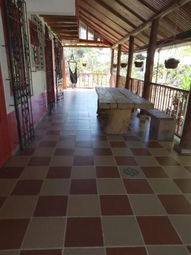 a porch with a wooden table and a checkered floor at Finca La Vistosa in Sasaima