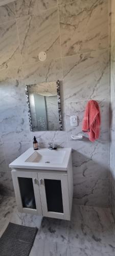 a bathroom with a white sink and a mirror at KUSI Casas de alquiler in Liebig
