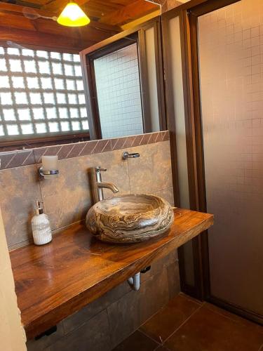a bathroom with a stone sink on a wooden counter at Parota in Mazamitla