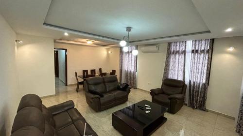 a living room with couches and chairs and a table at Mubi House in Kinshasa