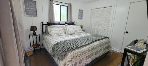 a bedroom with a bed with a comforter and a window at Mountain Lake Retreat I Getaway with Stunning Views in Topton