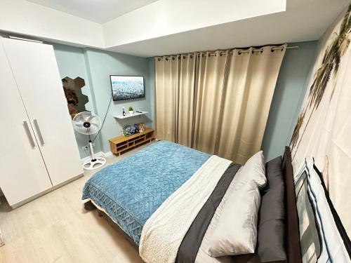 a bedroom with a bed with blue walls at Azure Staycation Beach Vibe by A M in Manila
