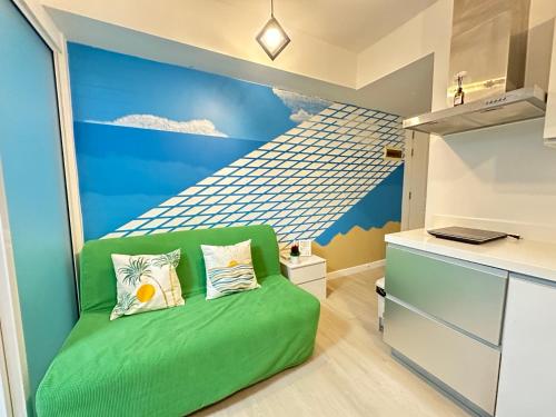 a bedroom with a green couch in a room with a mural at Azure Staycation Beach Vibe by A M in Manila