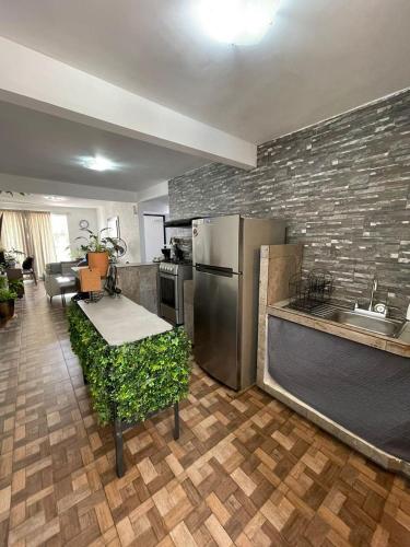 a kitchen with a stainless steel refrigerator and a table at Cómodo Depto frente a plaza Américas Xalapa Ver in El Castillo