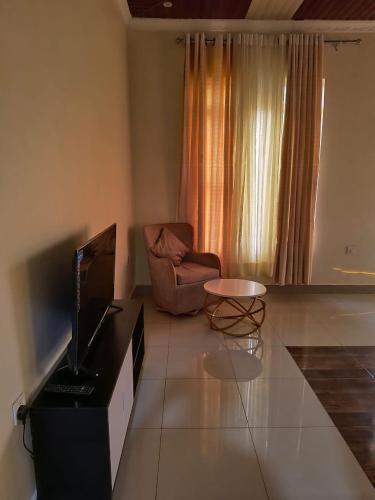 a living room with a television and a chair at Kigali Mechatronics Villa in Kigali