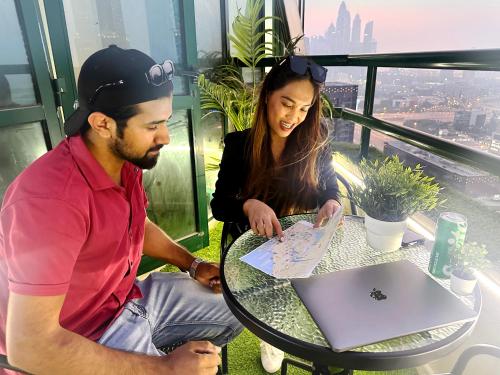 a man and a woman sitting at a table with a laptop at Quiet Partition Room in Tecom Barsha Heights in Dubai