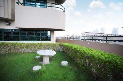 a white table in the grass in front of a building at Quiet Partition Room in Tecom Barsha Heights in Dubai