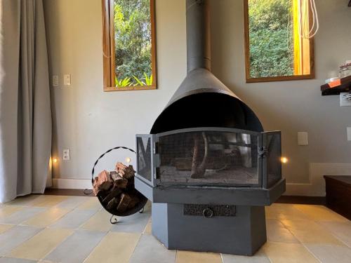 a fireplace in a living room with a wood stove at Auberge Suisse Pousada in Nova Friburgo