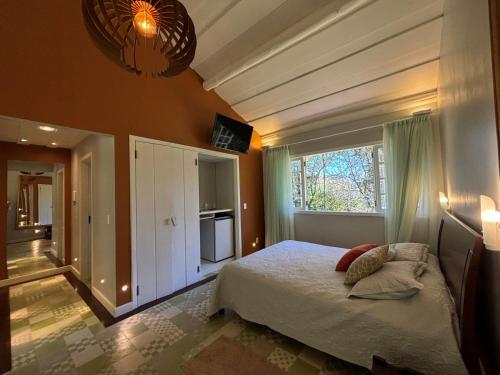 a bedroom with a bed and a large window at Auberge Suisse Pousada in Nova Friburgo