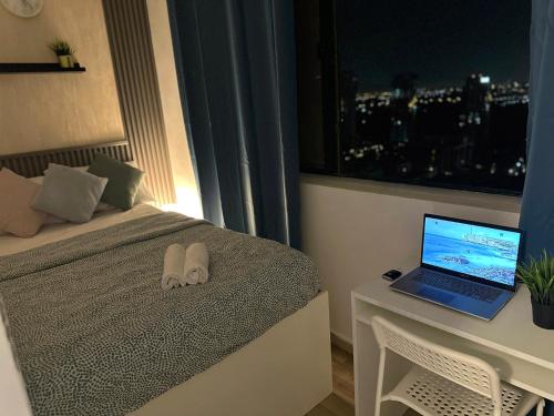 a bedroom with a bed and a laptop on a desk at Horizon View Partition Room in Barsha Heights Near Metro in Dubai