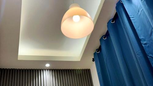 a light hanging from a ceiling with a blue curtain at Horizon View Partition Room in Barsha Heights Near Metro in Dubai